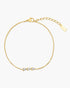 Gold bracelet with three small stones on a white background