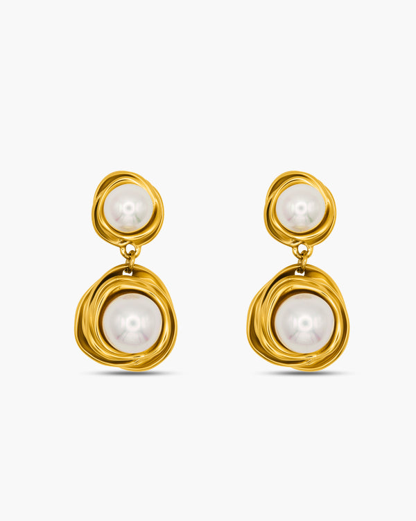 Gold earrings with pearl drops on a white background