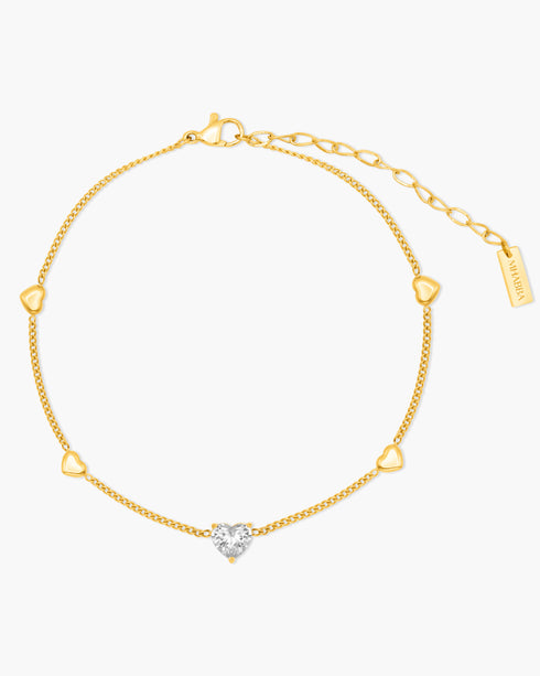 Gold anklet with a heart-shaped diamond on a white background