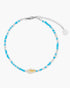 Beaded anklet with blue and white beads on a white background