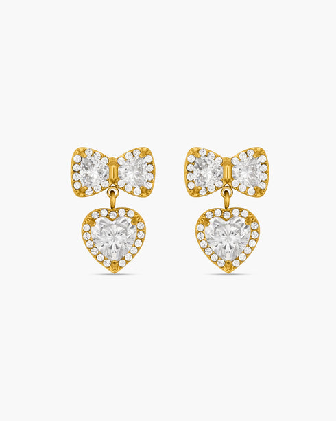 Gold bow-shaped earrings with heart details on a white background