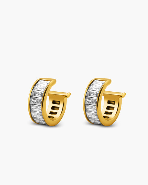 Gold hoop earrings with a white stone on a light gray background