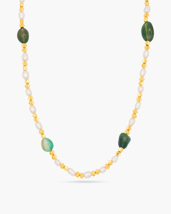 Necklace with green and gold beads on a white background