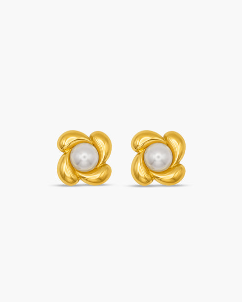 Pair of gold earrings with pearl centers on a white background