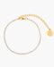 Gold bracelet with a round charm on a white background