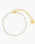Gold bracelet with a round charm on a white background
