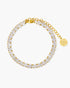 Gold bracelet with clear gemstones on a white background