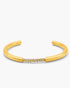 Gold bangle with small stones on a white background