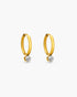 Gold hoop earrings with embedded diamonds on a white background