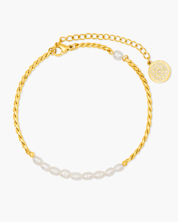 Gold anklet with pearl accents on a white background
