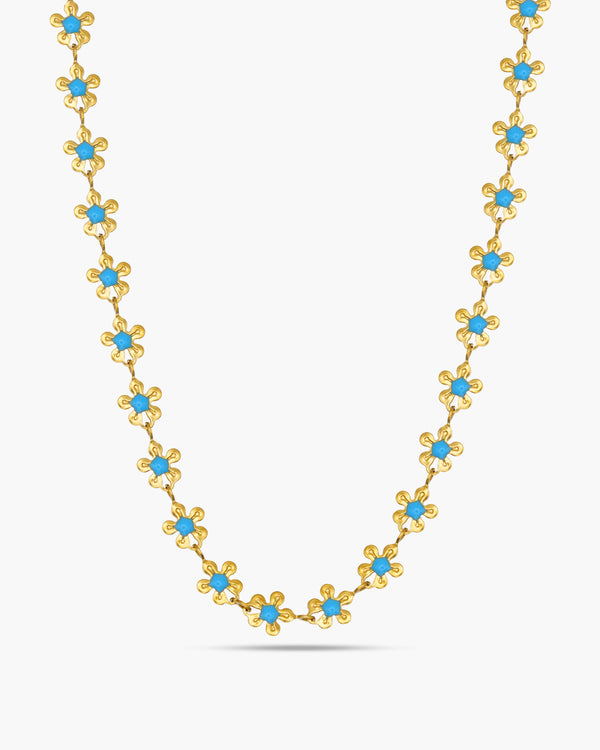 Gold necklace with blue stones on a white background