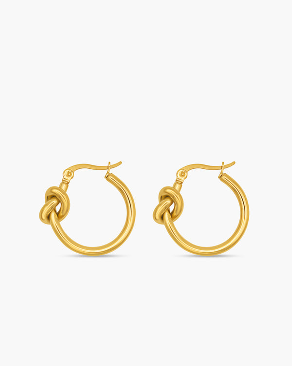 Gold hoop earrings with a knot design on a white background