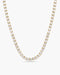 Gold necklace with clear stones on a white background