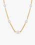 Gold chain necklace with white pearls on a white background