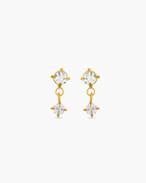 Gold earrings with clear gemstones on a white background