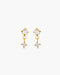 Gold earrings with clear gemstones on a white background
