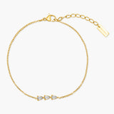 Gold bracelet with three small stones on a white background