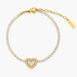 Gold bracelet with a heart-shaped charm on a white background