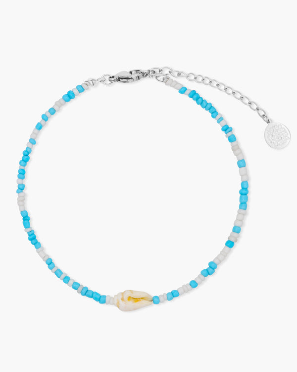 Beaded anklet with blue and white beads on a white background