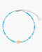Beaded anklet with blue and white beads on a white background