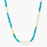 Necklace with turquoise beads and pearls on a white background
