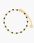 Gold anklet with black beads on a white background