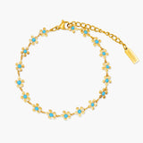 Gold bracelet with turquoise stones on a white background