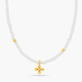 Necklace with white beads and a gold cross pendant on a white background