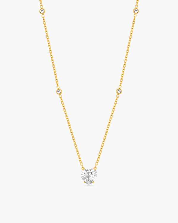 Gold necklace with a diamond pendant on a white background