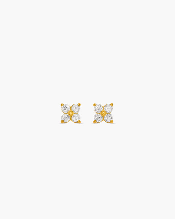 Pair of gold earrings with diamond-like stones on a white background