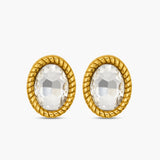 Gold earrings with clear gemstones on a white background