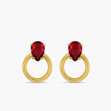 Gold hoop earrings with red gemstones on a white background
