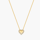 Gold necklace with a heart-shaped pendant on a white background
