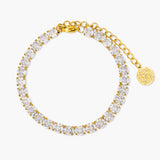 Gold bracelet with clear gemstones on a white background