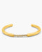 Gold bangle with small stones on a white background