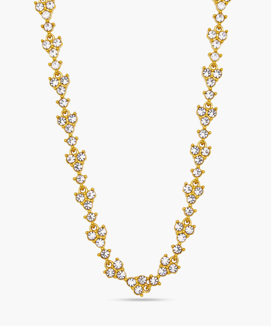 Gold necklace with clear stones on a white background
