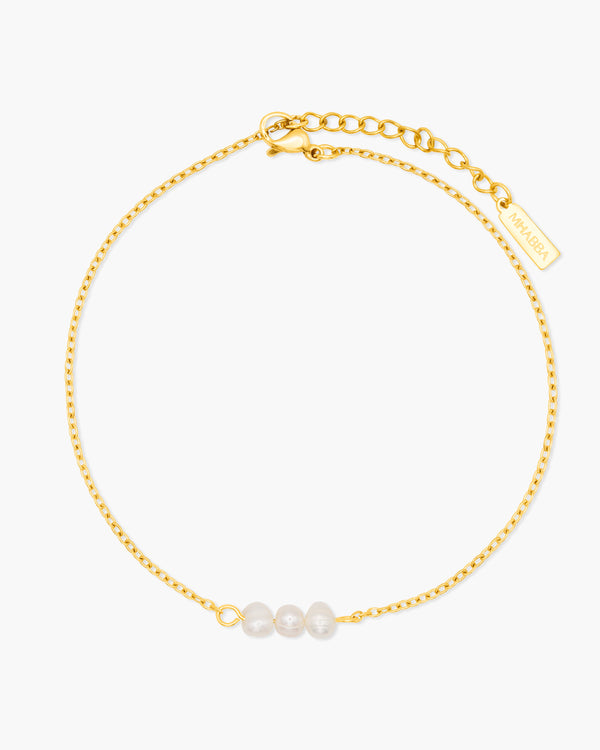 Gold anklet with three pearls on a white background