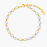 Pearl anklet with gold accents on a white background