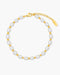 Pearl anklet with gold accents on a white background