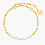 Gold anklet with pearl accents on a white background