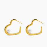 Gold hoop earrings with pearl centers on a white background