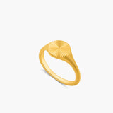 Gold ring with a sunburst design on a white background