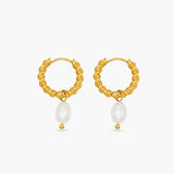 Gold hoop earrings with pearl drops on a white background