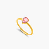 Gold ring with a pink gemstone on a white background