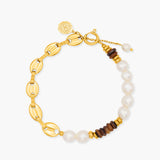 Gold bracelet with pearls and wooden beads on a white background