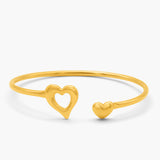 Gold bracelet with heart designs on a white background