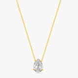 Gold necklace with a clear teardrop-shaped pendant on a white background