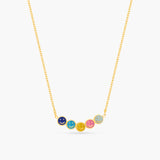Necklace with colorful round pendants on a gold chain against a white background