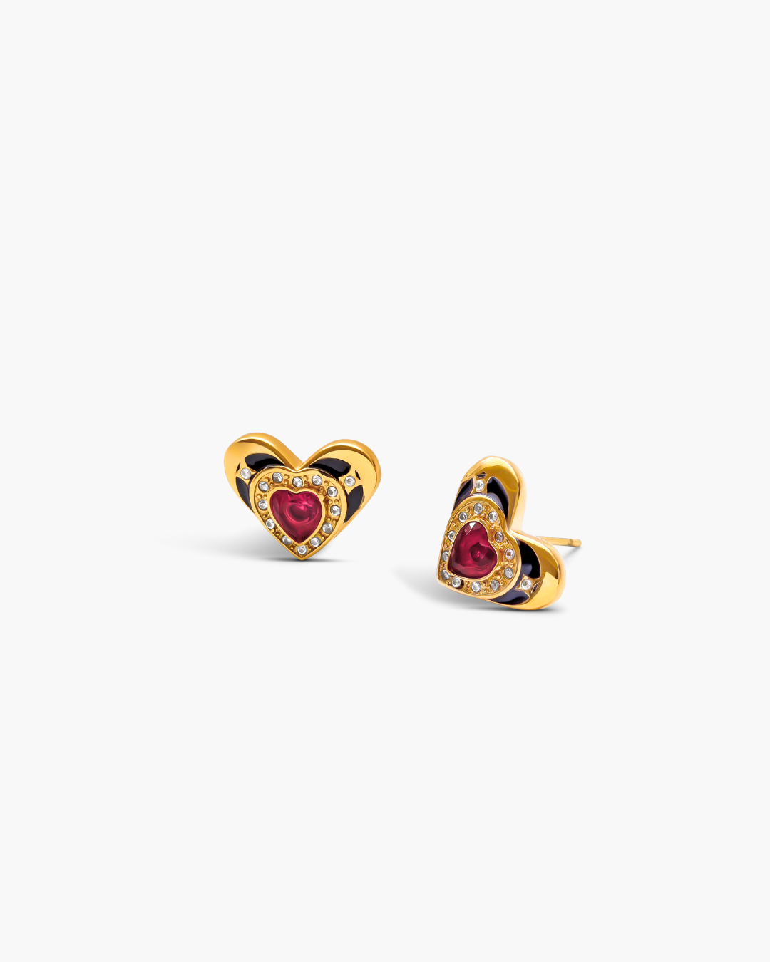 Heart-shaped earrings with red gemstones and gold accents on a white background