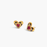 Heart-shaped earrings with red gemstones and gold accents on a white background